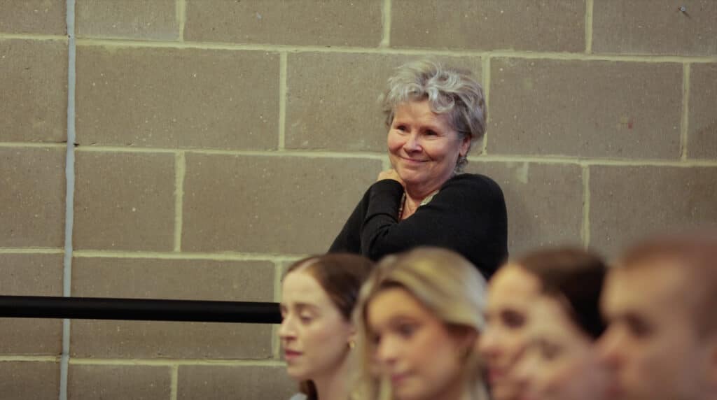 Imelda smiles as she watches students work